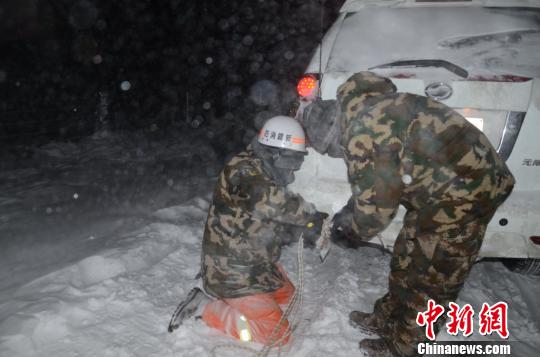 圖為消防救援人員給被困車輛安裝救援繩。　李江江 攝